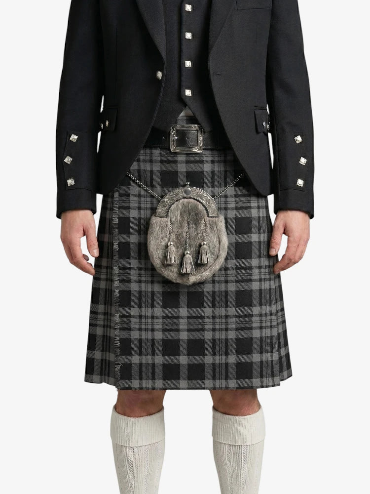 Person wearing a traditional Scottish kilt with a black jacket on a white background