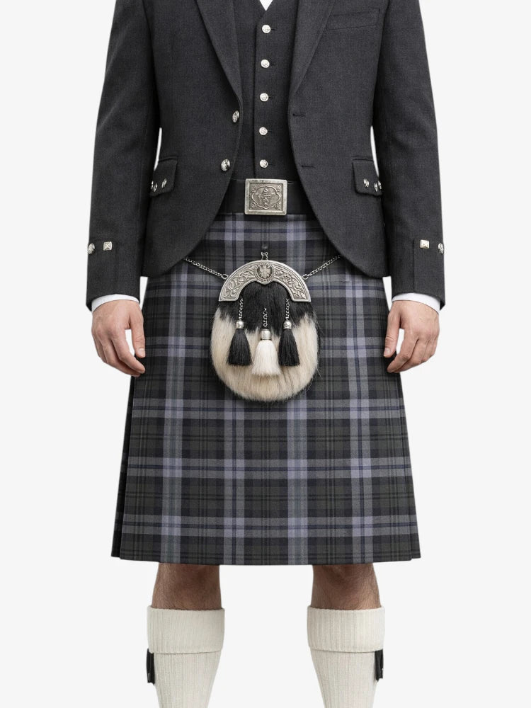Person wearing a traditional Scottish kilt with a jacket and waistcoat on a white background