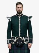 Man wearing a dark green doublet jacket with white trim and a black watch tartan kilt on a white background