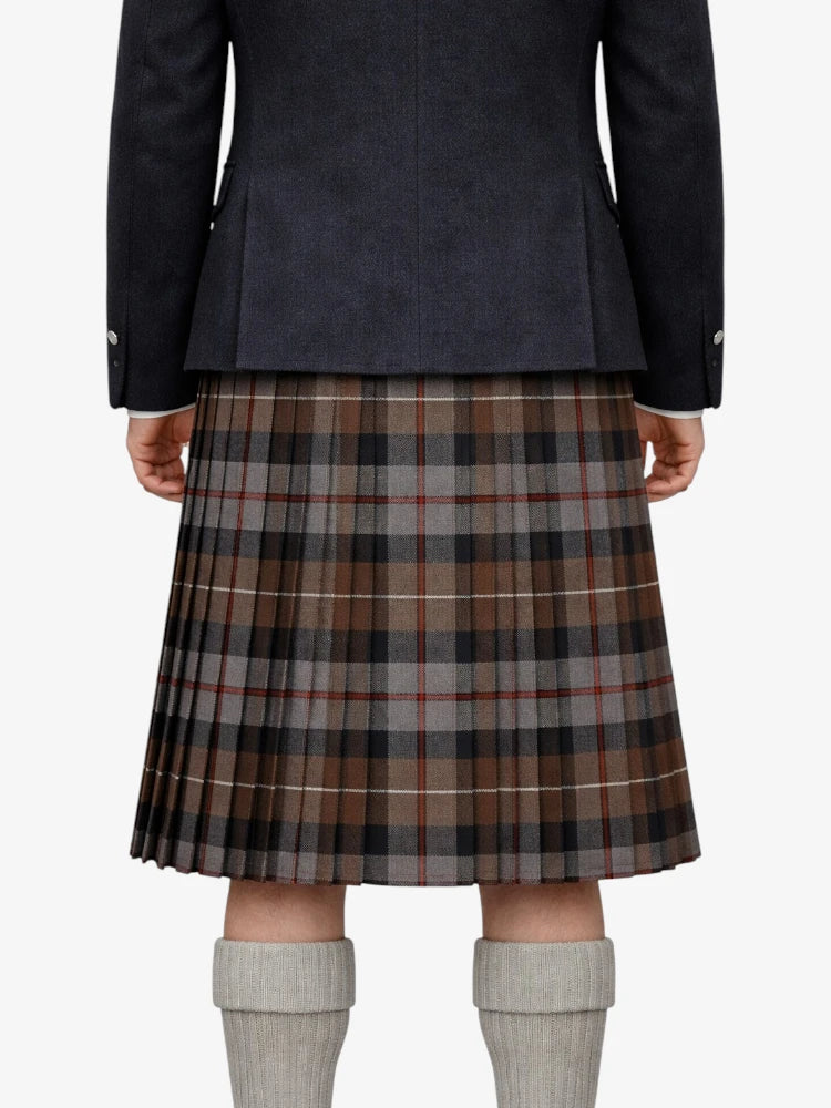 Person wearing a dark jacket and plaid kilt on a white background