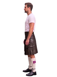 A man shown in profile wearing a black leather kilt, a white t-shirt, white socks with a purple accent, and black shoes, against a plain white background.