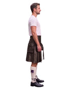 A man shown in profile wearing a black leather kilt, a white t-shirt, white knee-high socks, and black leather shoes, against a solid white background.