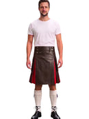 A man modeling a dark brown faux-leather kilt with red side panels, paired with a white t-shirt, white knee-high socks, and black lace-up shoes, against a plain white background.