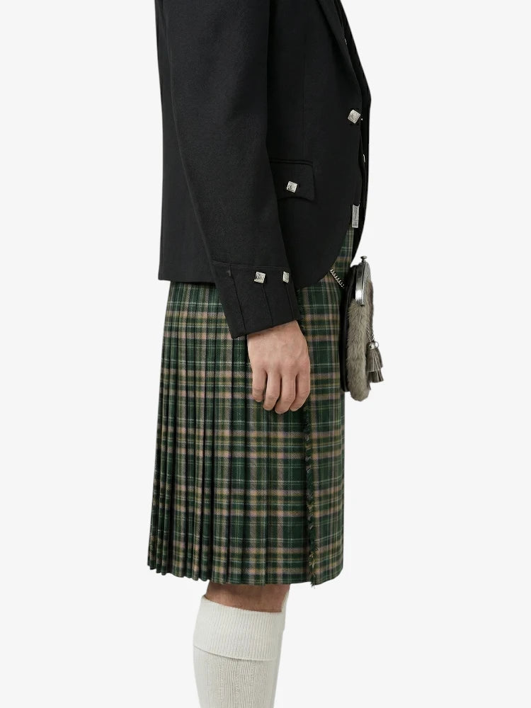 Person wearing a black jacket and green plaid kilt on a white background