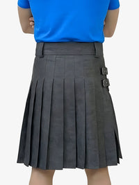 Person wearing a blue shirt and gray pleated skirt on a white background