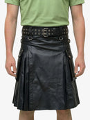 Person wearing a black leather kilt with a green shirt on a white background