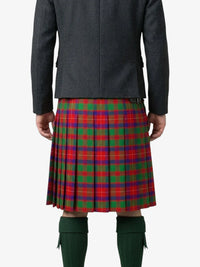 Person wearing a red and green plaid kilt with a gray jacket on a white background