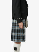 Person wearing a black jacket and plaid kilt on a white background