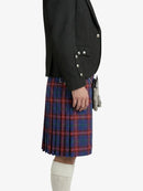 Person wearing a black blazer and red plaid kilt on a white background