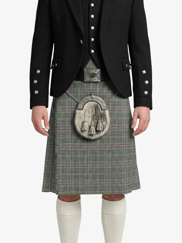 Person wearing a traditional Scottish kilt with a black jacket on a white background
