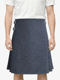 Person wearing a gray pleated skirt on a white background