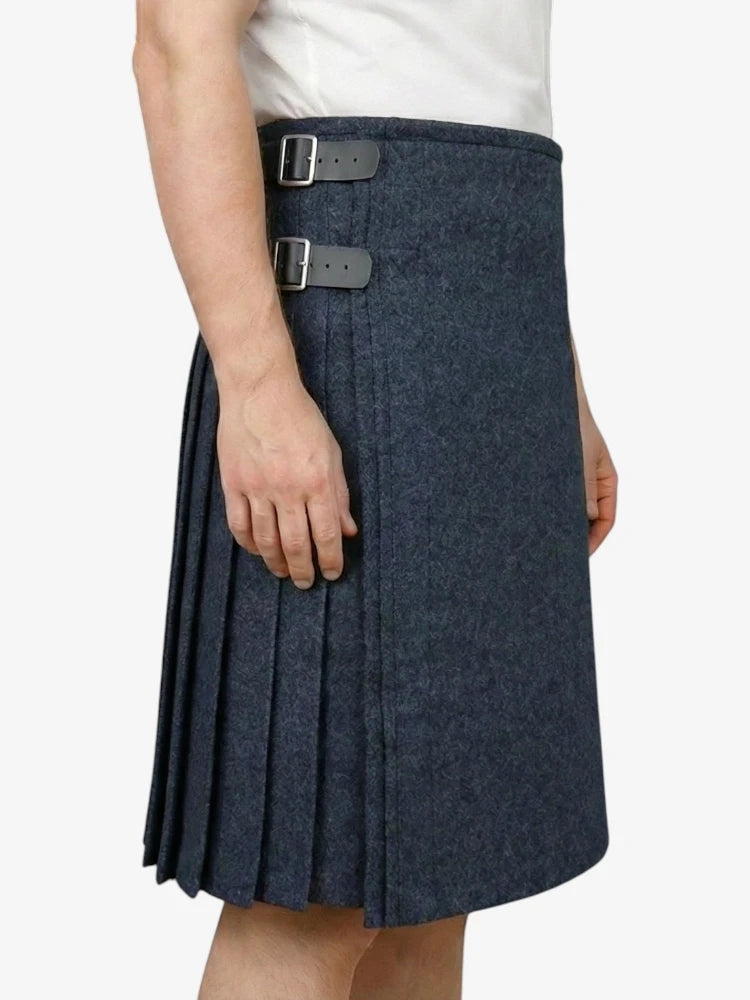 Person wearing a navy pleated skirt with a white background