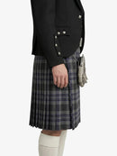 Person wearing a black jacket and plaid kilt on a white background