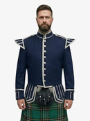 Man wearing a navy blue jacket with white trim and a irish national tartan kilt on a white background