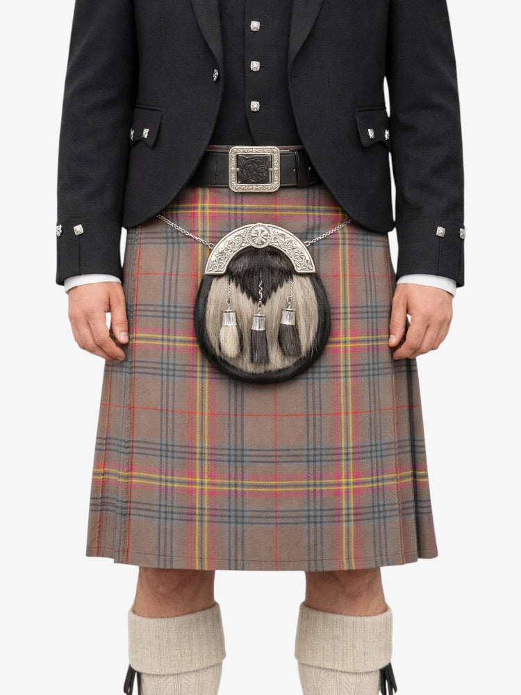 Person wearing a traditional Scottish kilt with a sporran on a white background