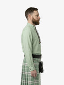 Man wearing a green shirt and plaid kilt on a white background