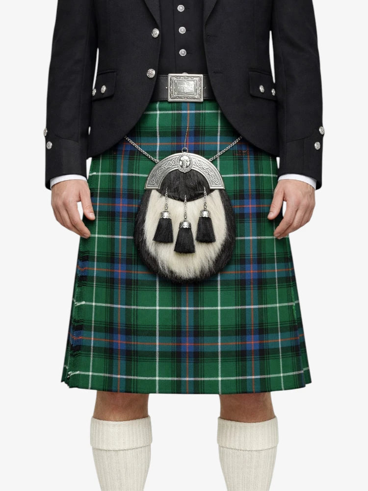 Person wearing a traditional Scottish kilt with a tartan pattern on a white background