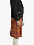 Person wearing a black jacket and plaid kilt on a white background