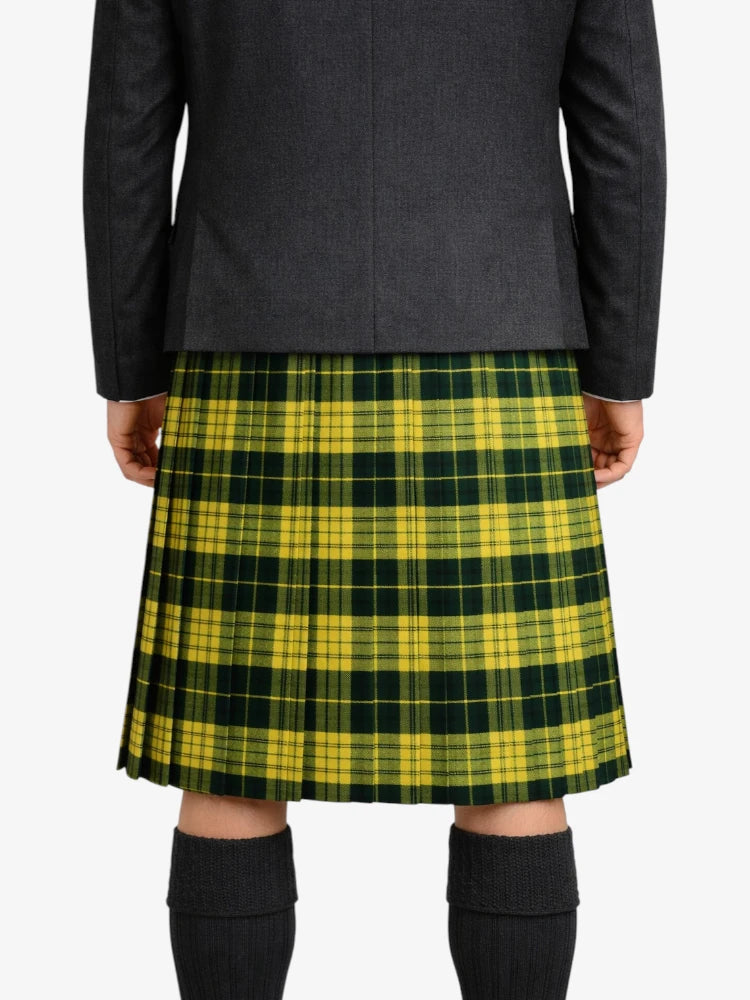 Person wearing a green and yellow plaid kilt with a dark coat on a white background