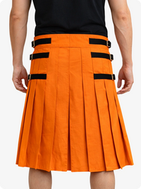 Orange pleated skirt with black straps worn by a person on a white background