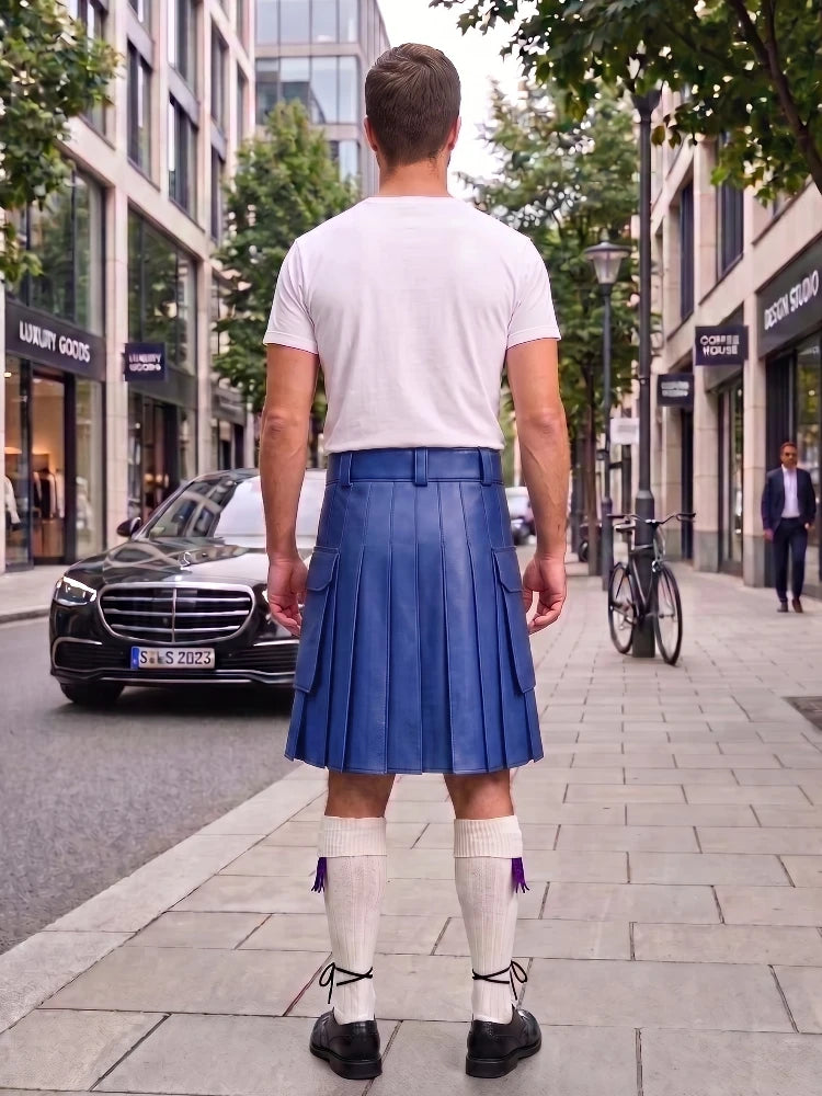 A man viewed from behind wearing a blue leather kilt, white t-shirt, white knee-high socks, and black shoes, standing on a city sidewalk.