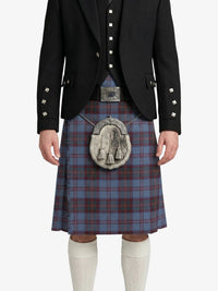 Person wearing a black jacket and blue plaid kilt with a silver sporran on a white background