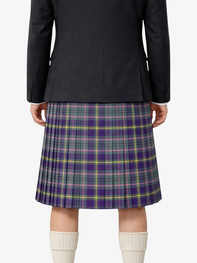 Person wearing a black jacket and plaid kilt on a white background
