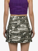 Person wearing a purple top and camouflage skirt on a white background